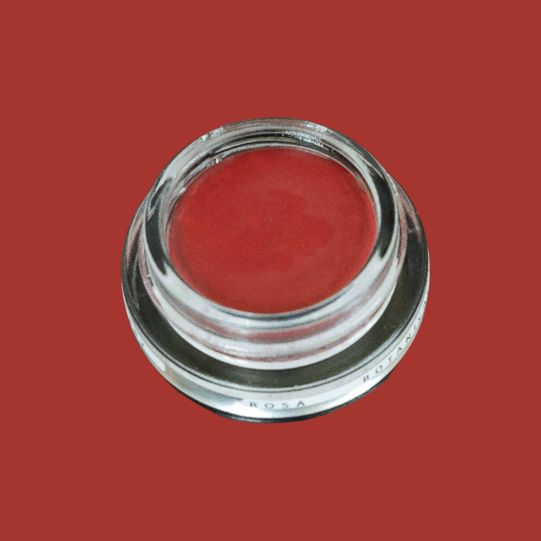 Glass pottle of Rosa lip tint, a soft, pink, red colour.