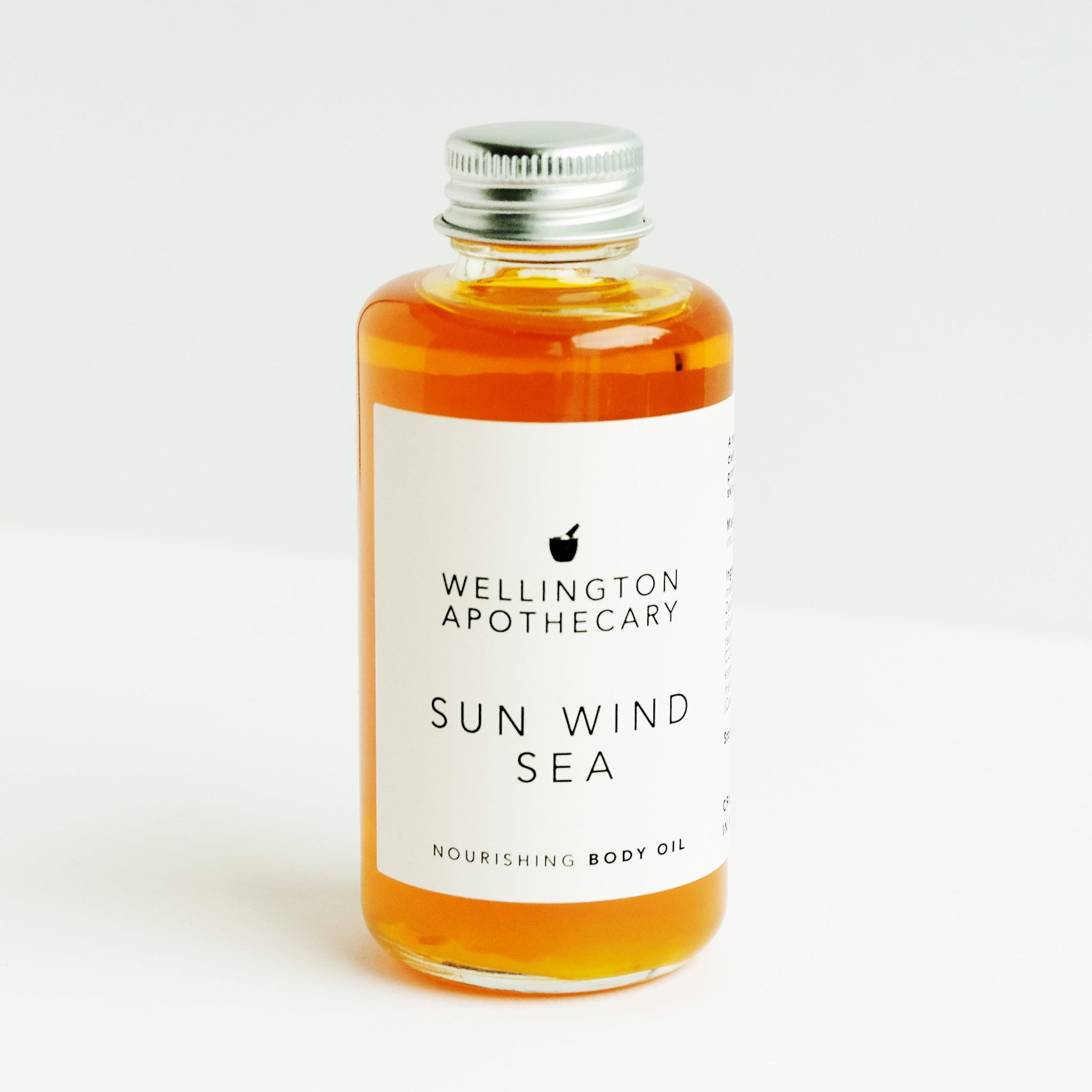 Bottle of Wellington Apothecary Sun Wind Sea body oil on a white background