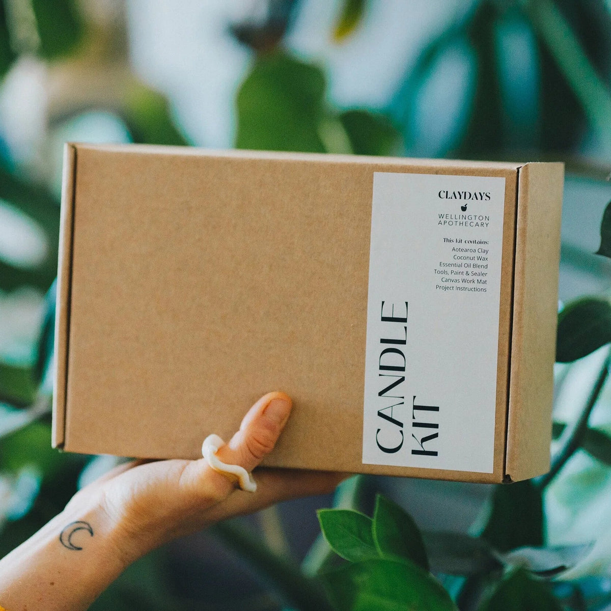 Hand holding a cardboard box labeled &