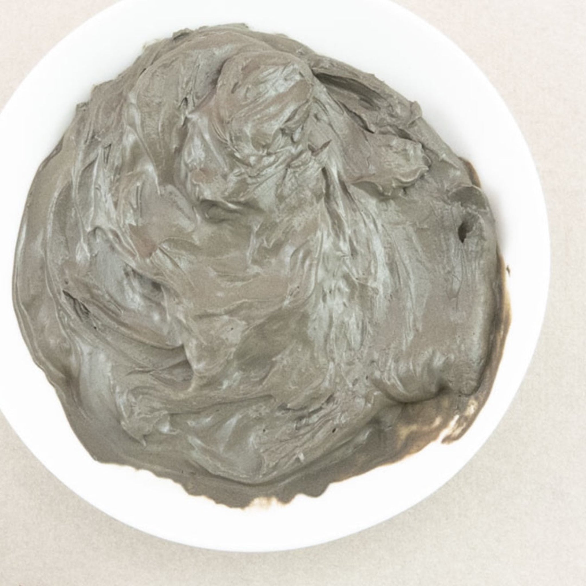 A small white bowl of mud from the Dead Sea.