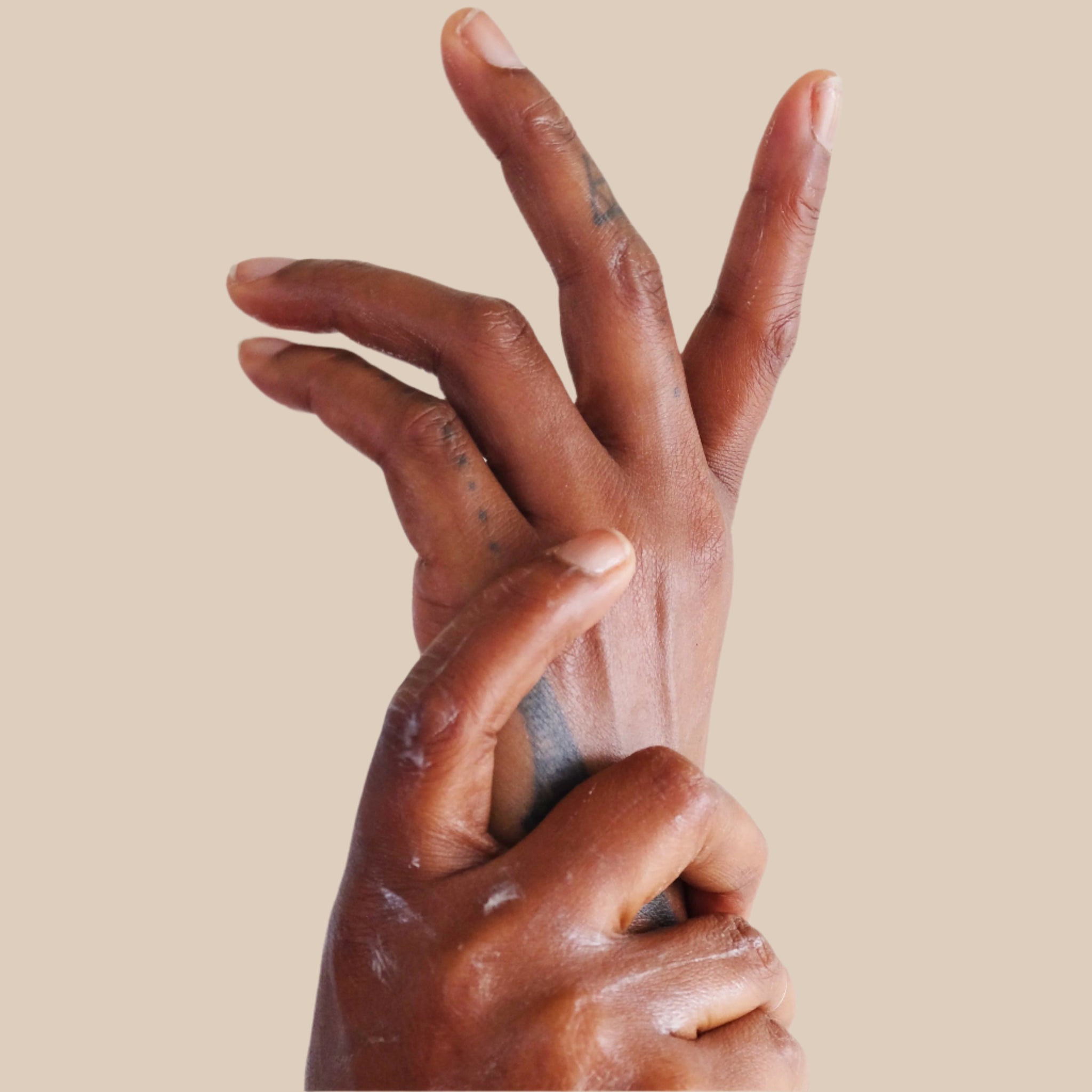 Close up of deva elegantly rubbing lotion onto her hands.
