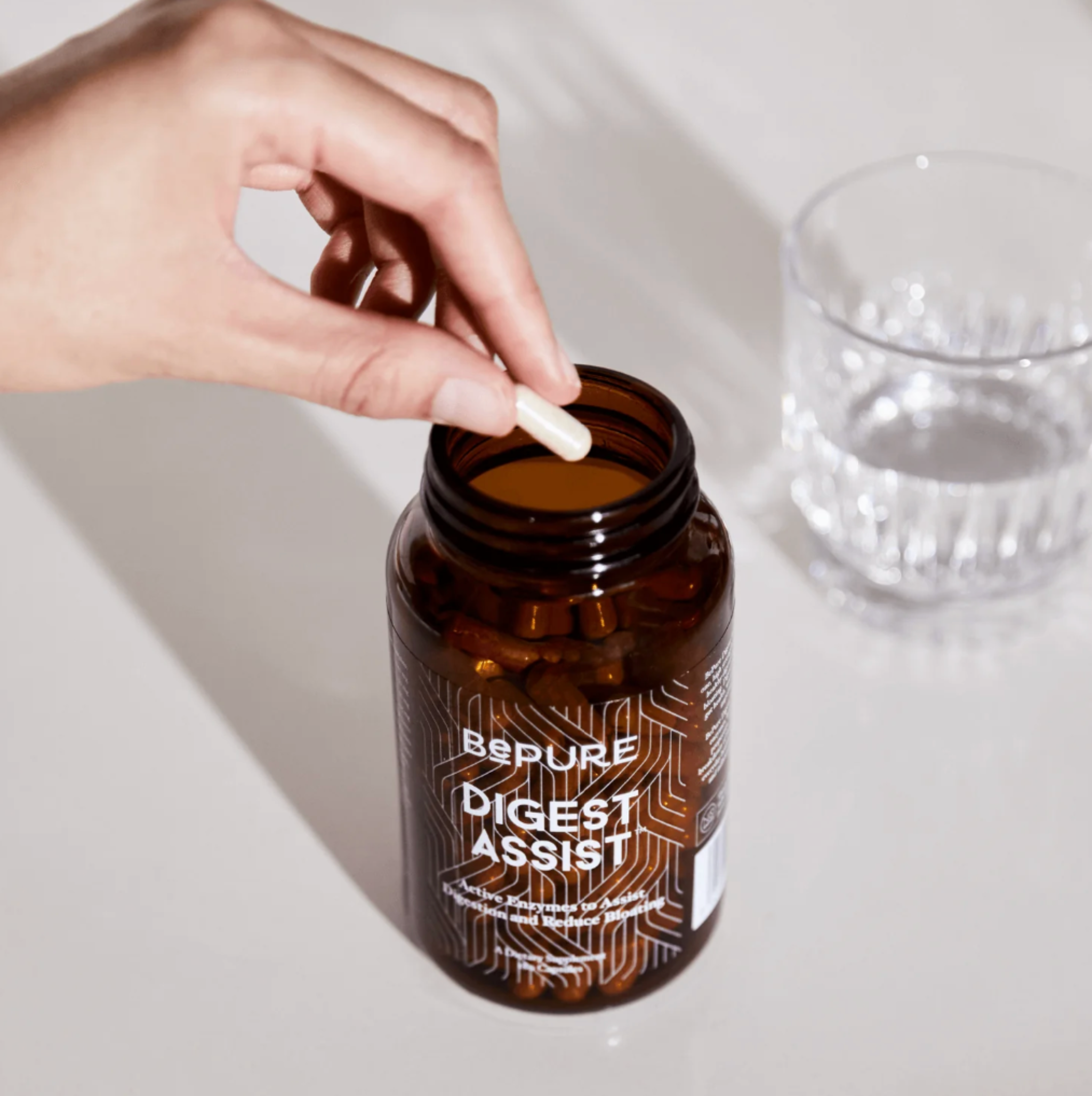 Hand holding a supplement bottle labeled &