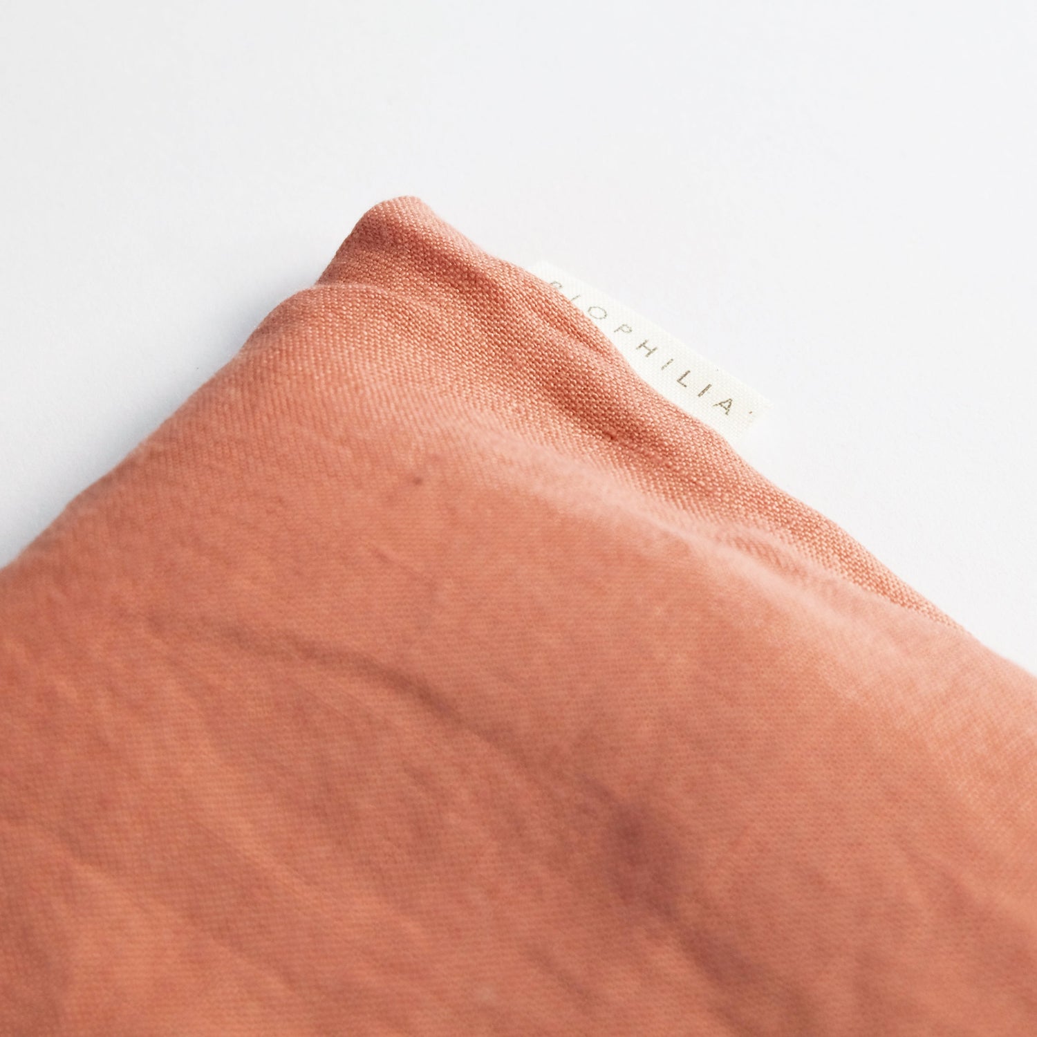 Close-up of a rose coloured linen eye pillow with &