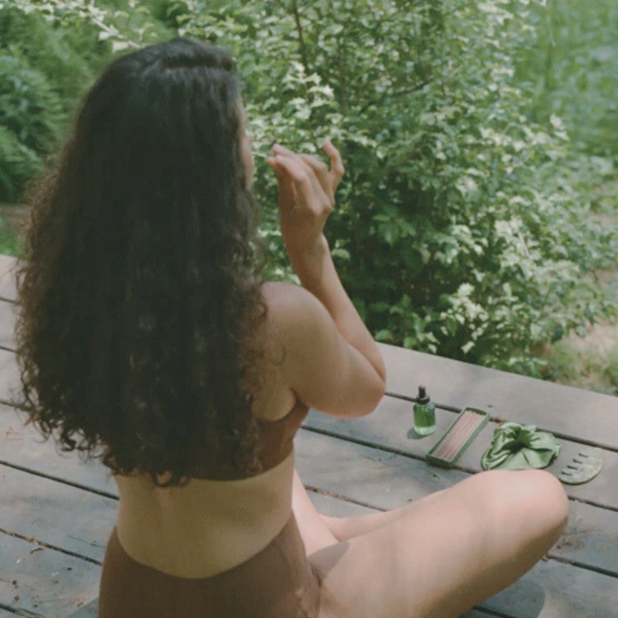 Woman sitting on a wooden deck with a natural background