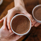Hands holding hot chocolate in mug.