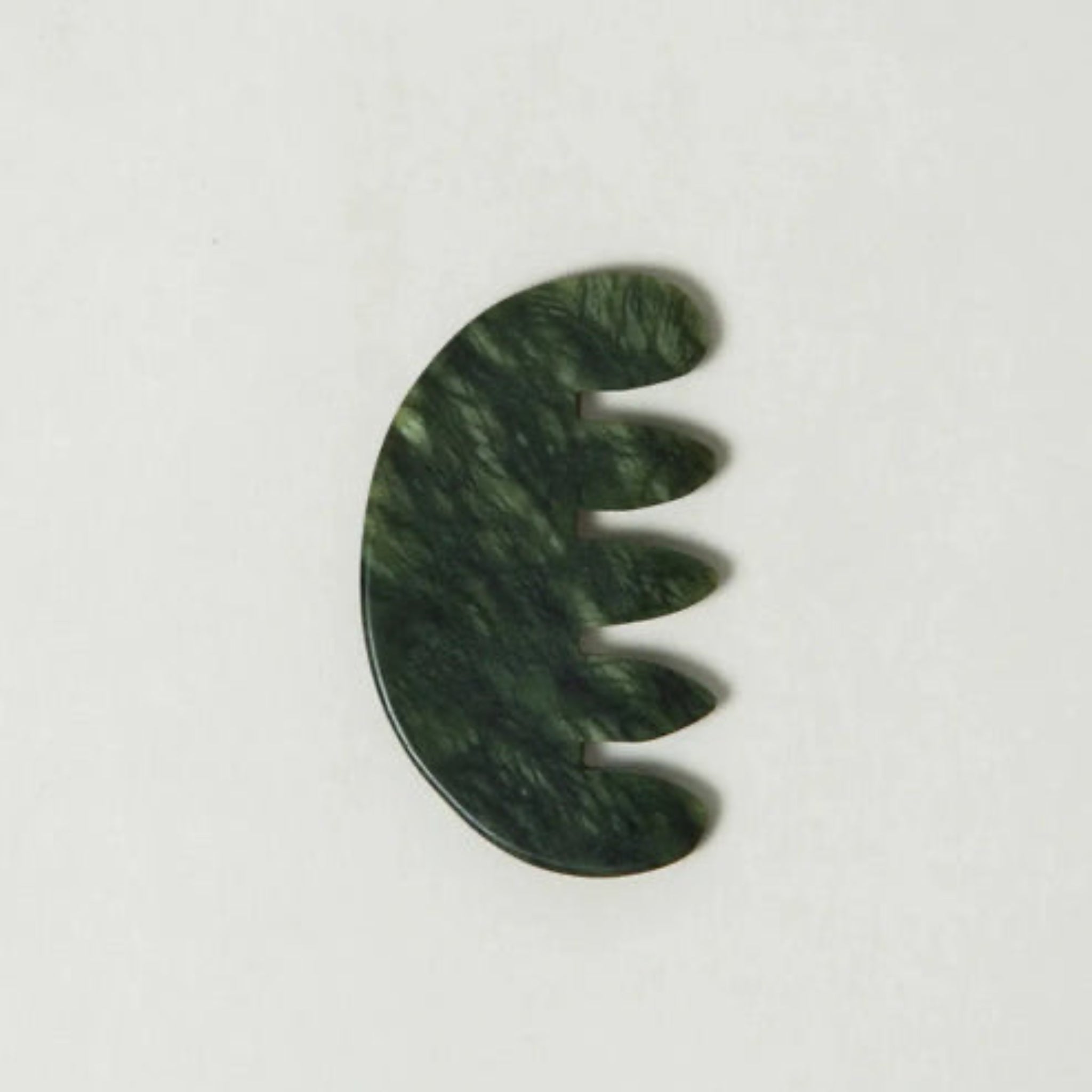 Green jade scalp stimulator on a white background