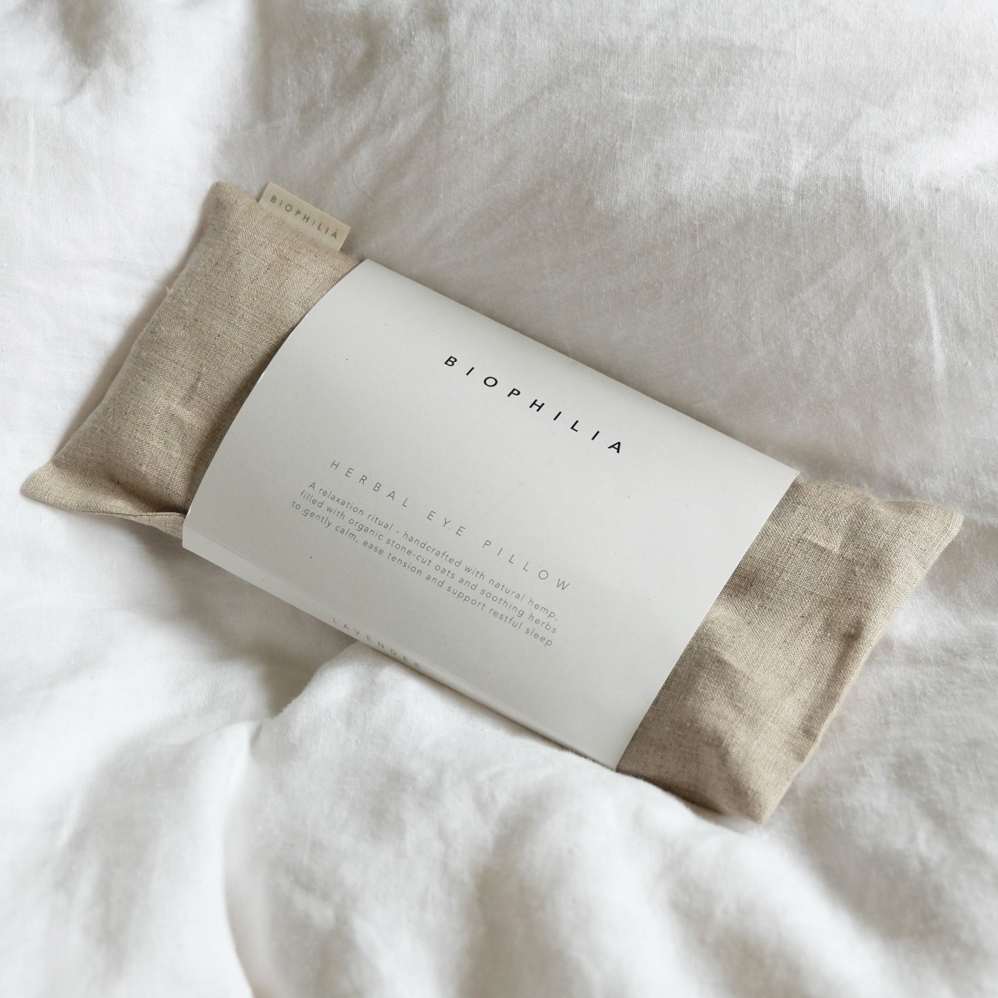 Herbal eye pillow with oat coloured linen on a white background