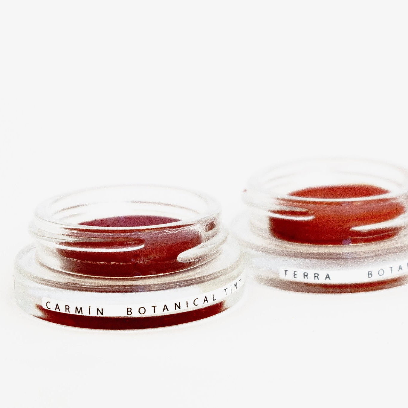 Three glass pottles in a row containing three shades of natural pigment lip tints.