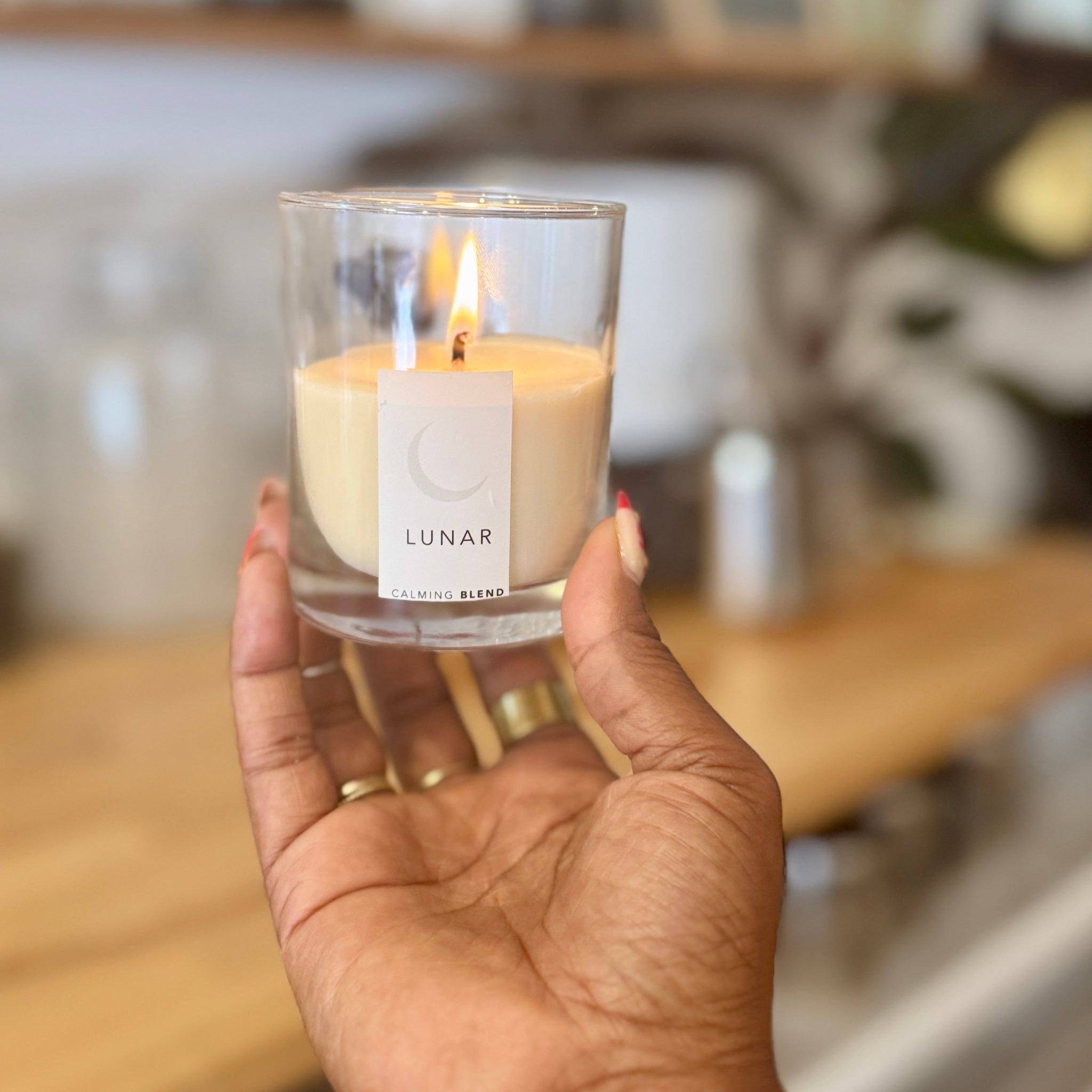 Hand holding a lit candle labeled &