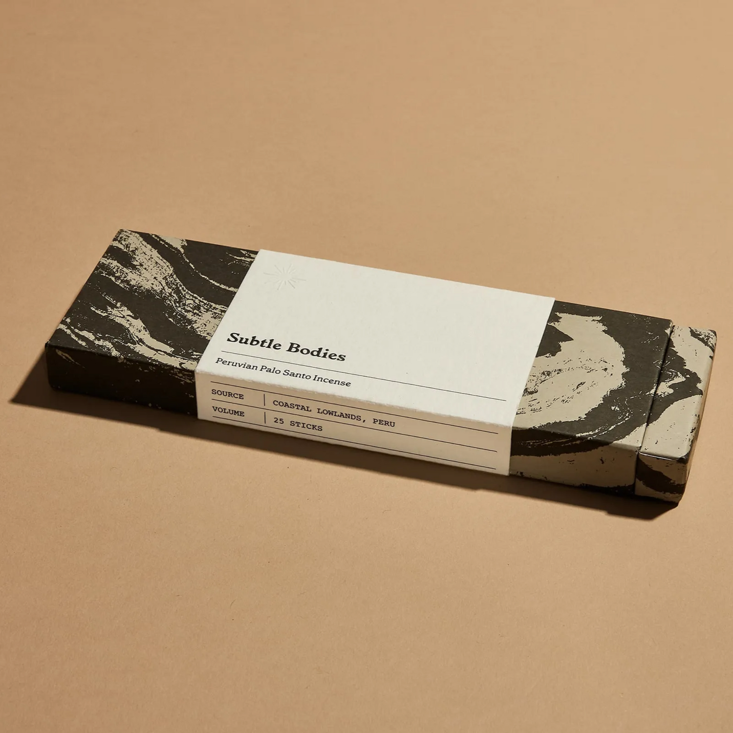 A box of Palo Santo incense on a beige surface.