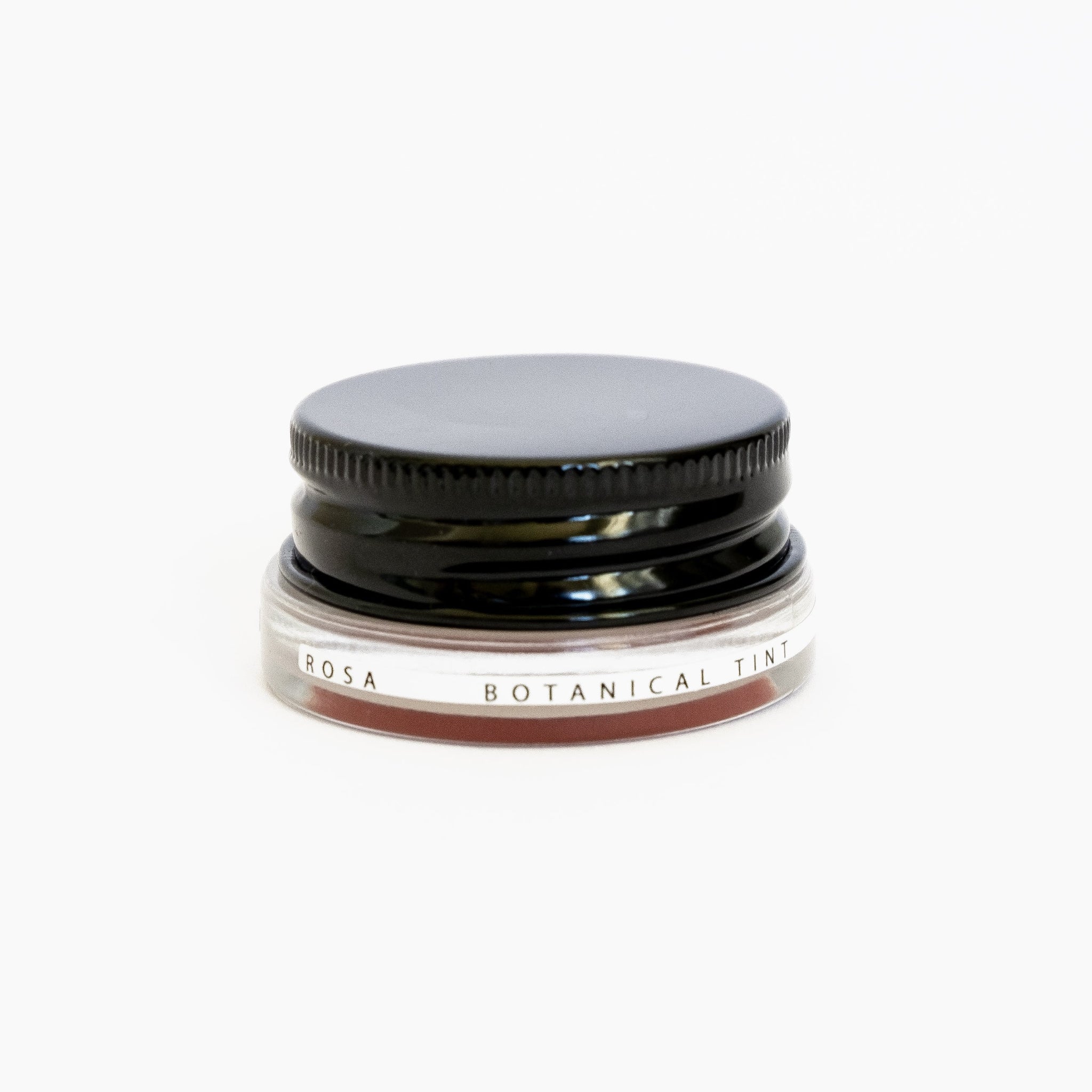 A small glass pottle of Rosa lip tint on white background.