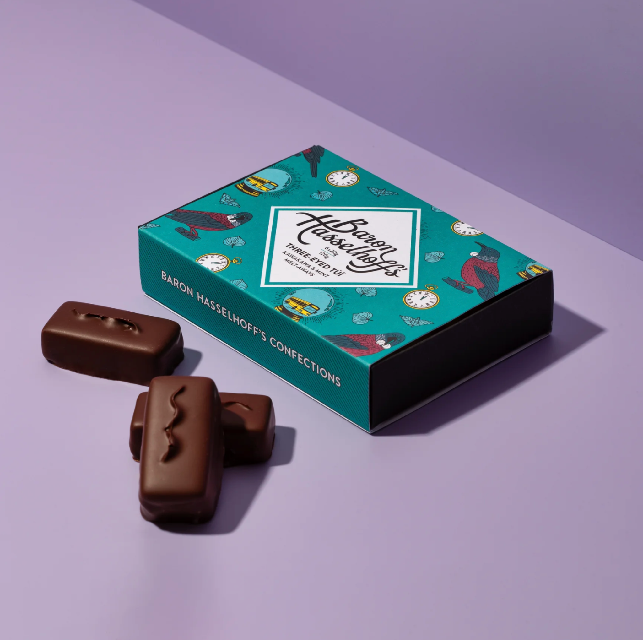 Chocolate confections with a decorative box on a light purple background