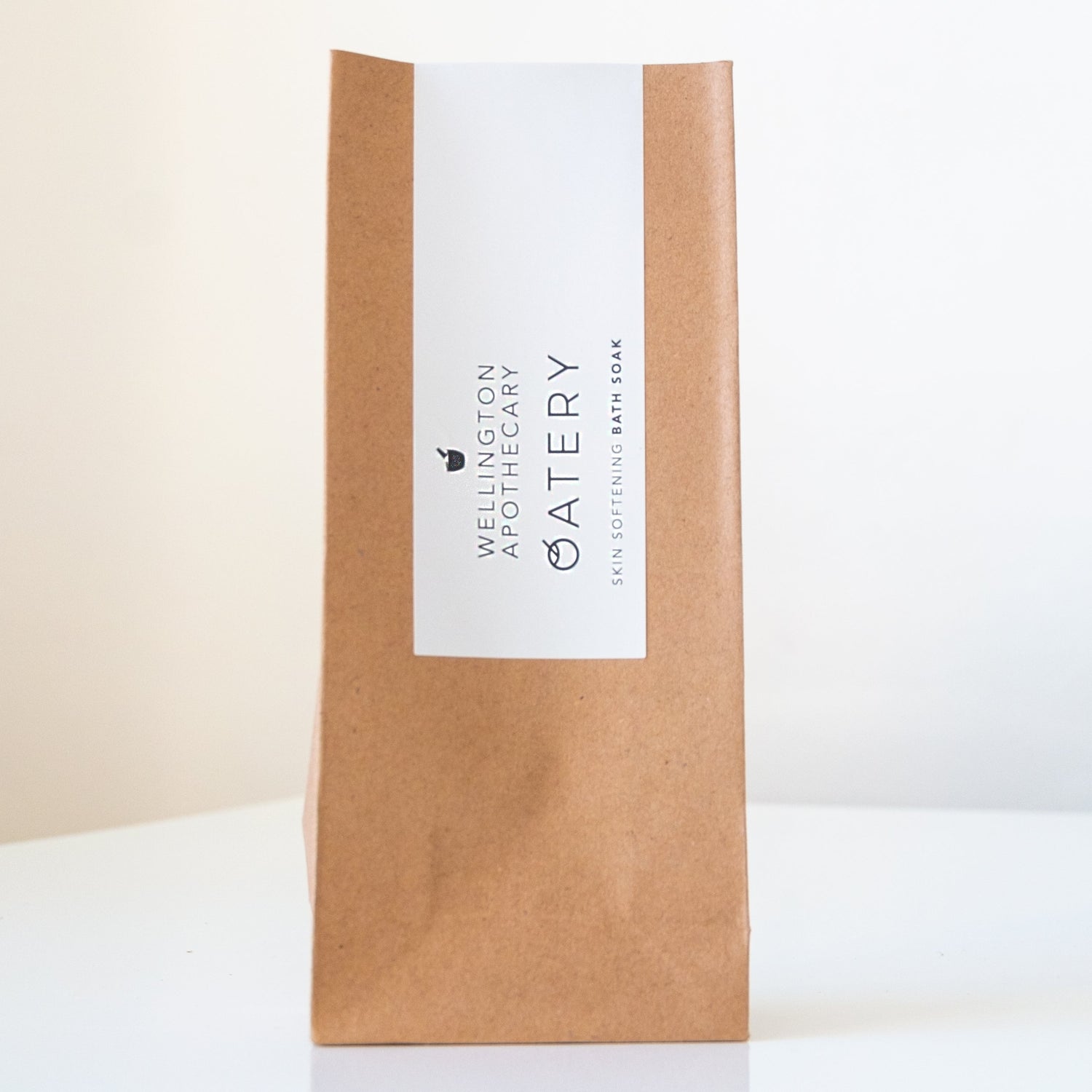 Crisp brown paper bag on white bench with white bath soak label.