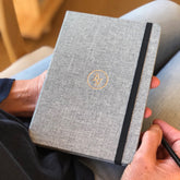 Mindfully Me journal held on lap with a pencil.