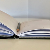 Mindfully Me journal open on bench with pencil inside.