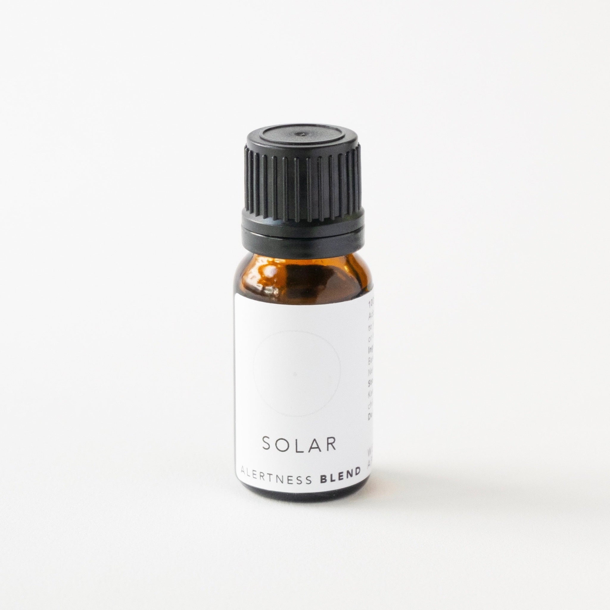 Small amber glass bottle of solar essential oil blend on white bench.
