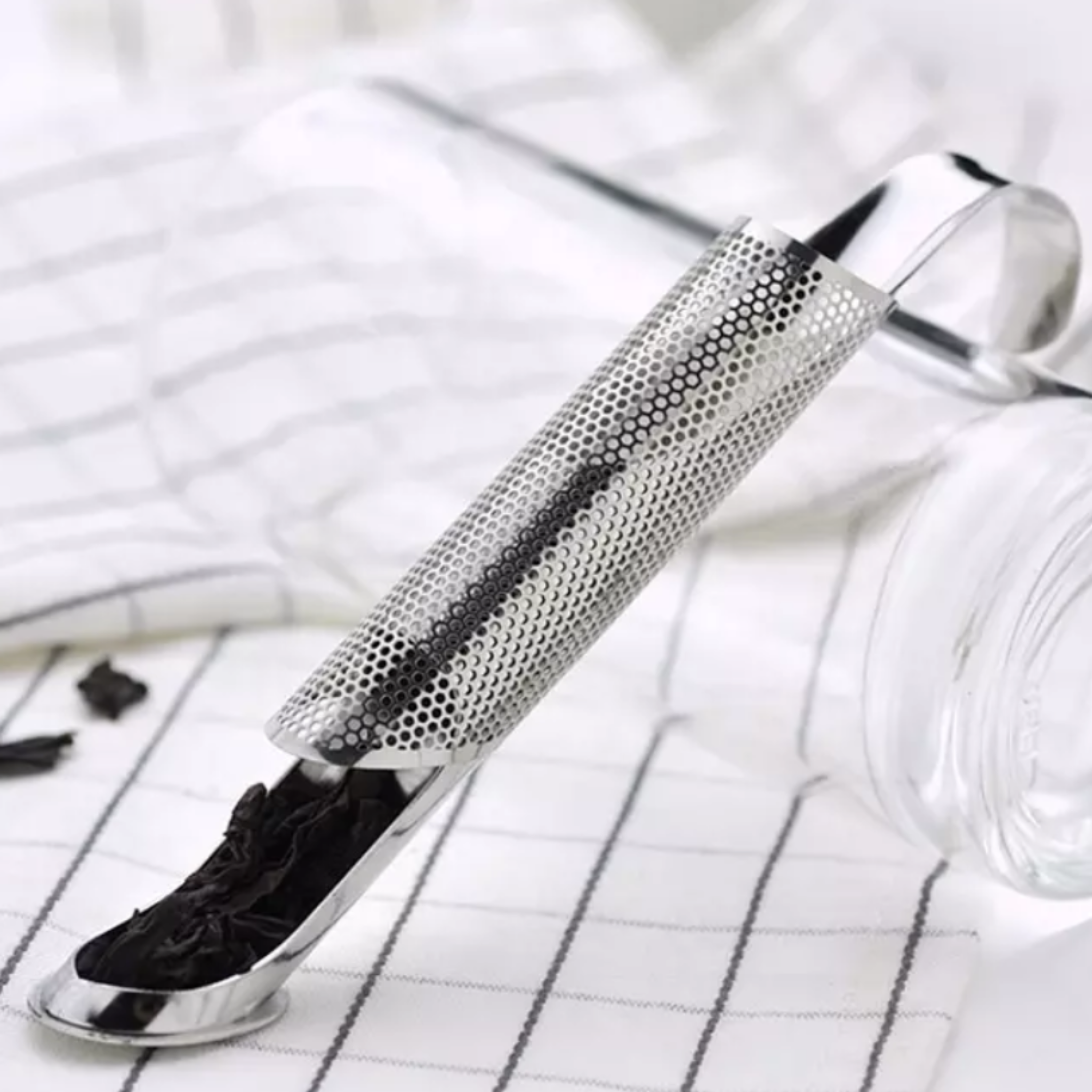 A cylindrical stainless steel tea infuser.