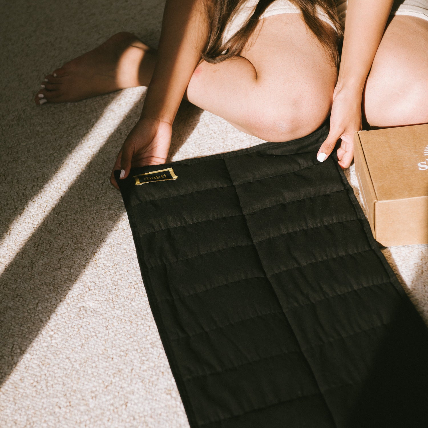 Person holding a black quilted weighted blanket