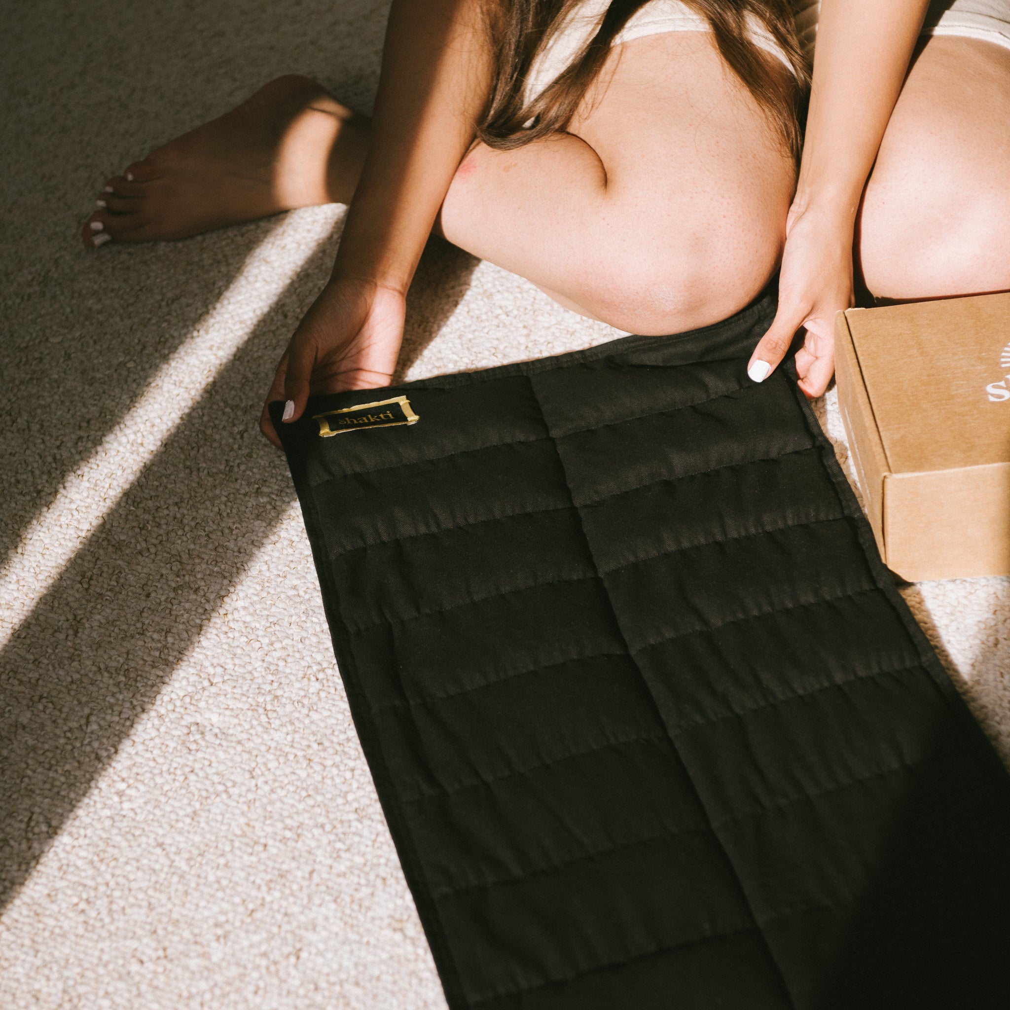 Person holding a black quilted weighted blanket