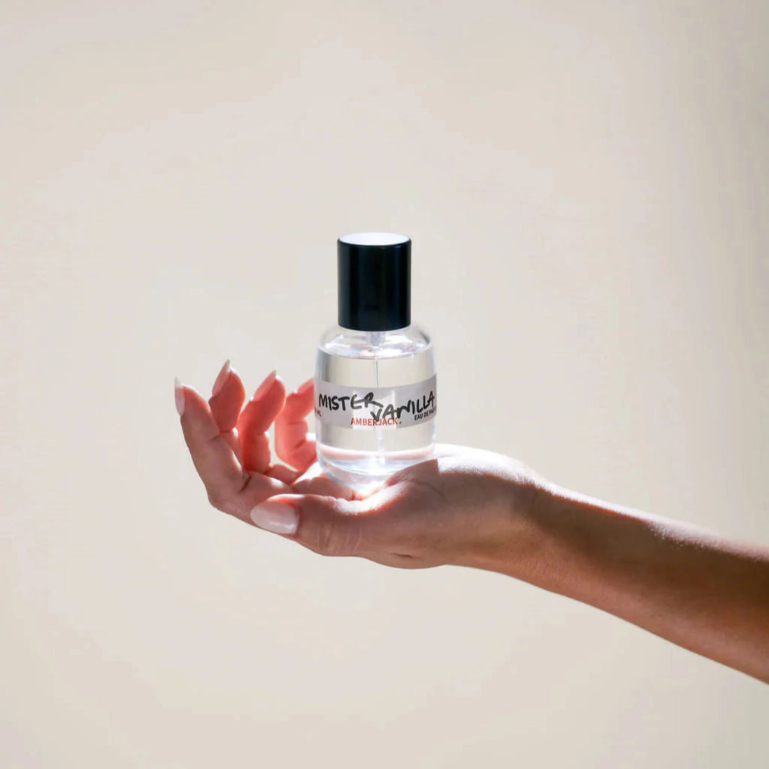 Hand holding a bottle labeled &