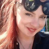 Person with sunglasses on head, smiling outdoors