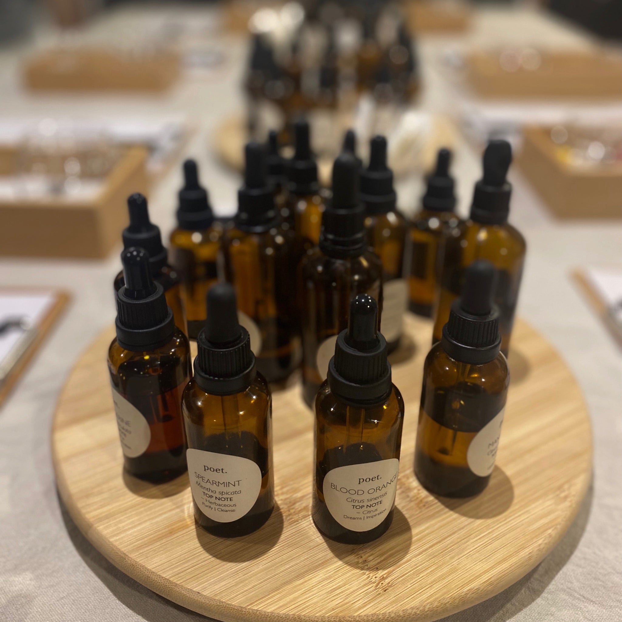Collection of brown glass bottles of essential oils on a wooden tray.