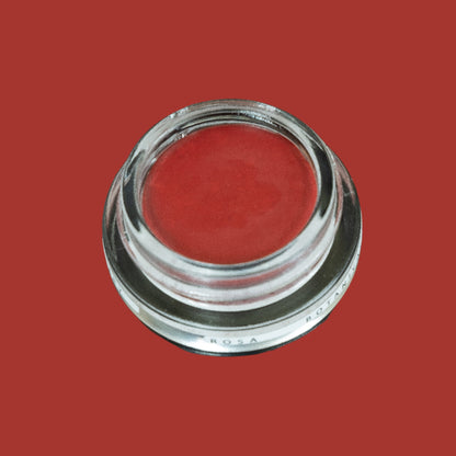 Glass pottle of Rosa lip tint, a soft, pink, red colour. 