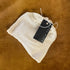 White bath tea bag with a black tag on a brown textured background