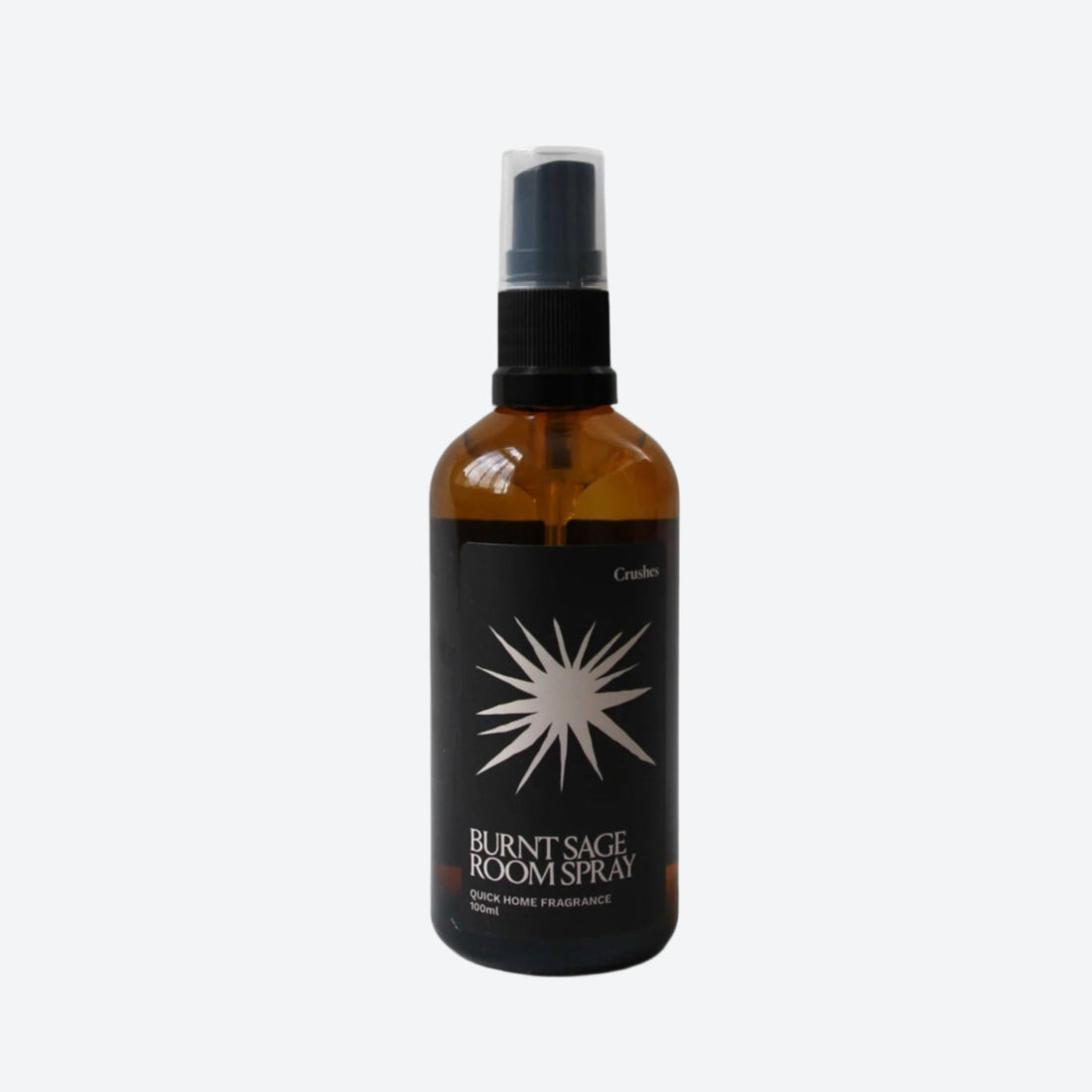 Amber glass spray bottle with burnt sage room spray on white background. 