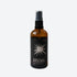 Amber glass spray bottle with burnt sage room spray on white background. 