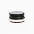 A small glass pottle of Carmín lip tint on white background. 