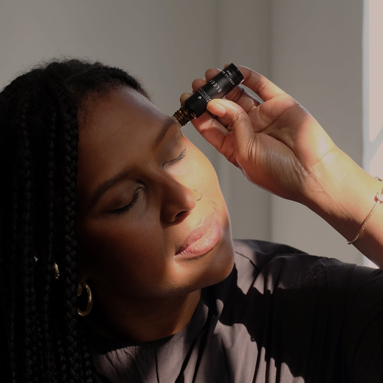Person applying a roll on sleep blend to their temples