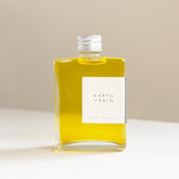 A large square glass bottle with aluminium lid containing the Earth + Rain scent therapy blend. 