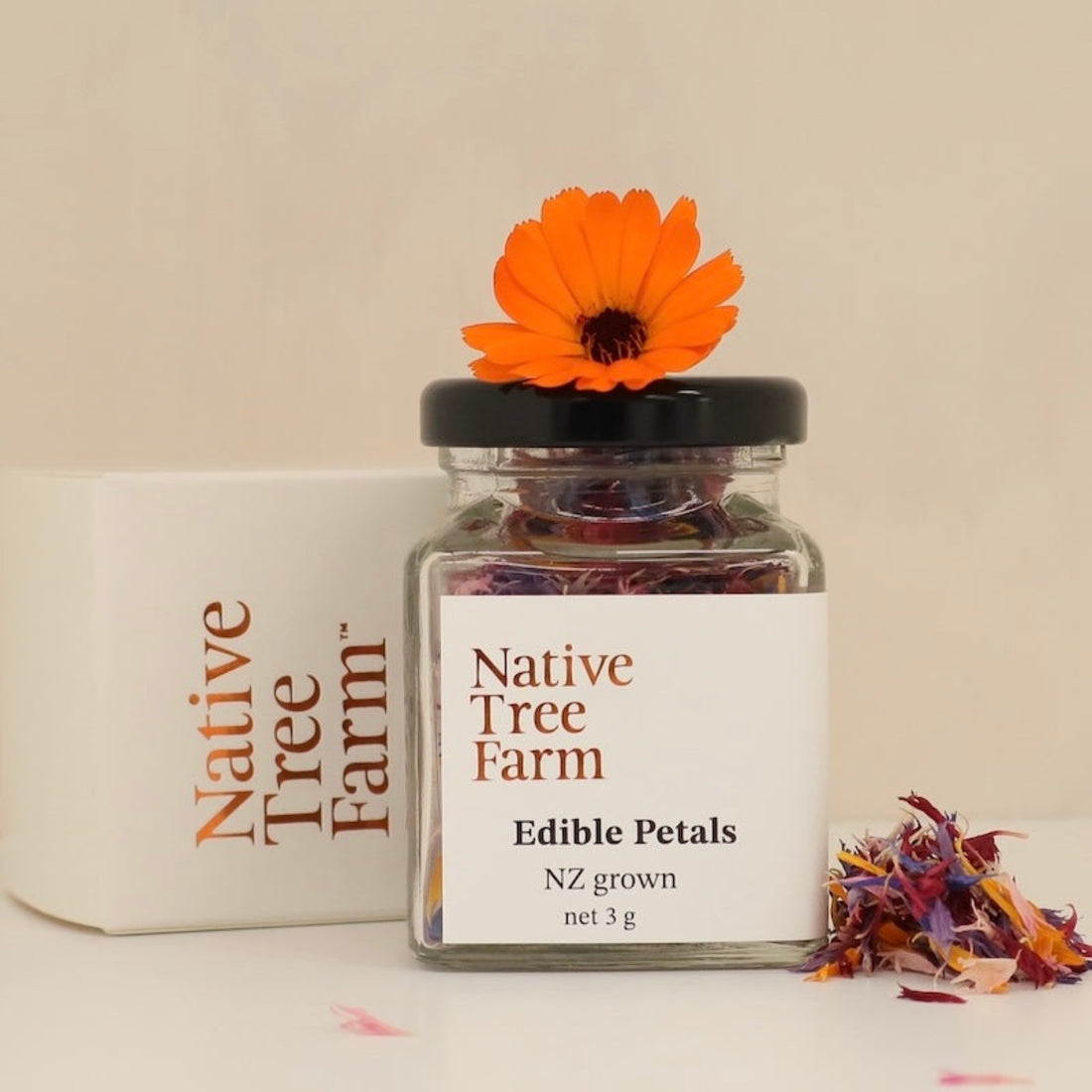 A glass jar of dried edible petals by Native Tree Farm for decorating baking and other foods.