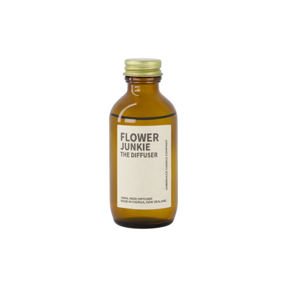 An amber bottle of Flower Junkie scent as a reed diffuser. 