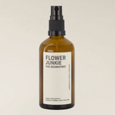 An amber glass room spray bottle with a black spray nozzle and a white label reading &