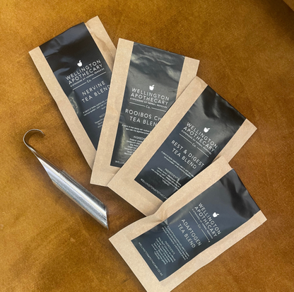 Tea packages from Wellington Apothecary on a brown surface
