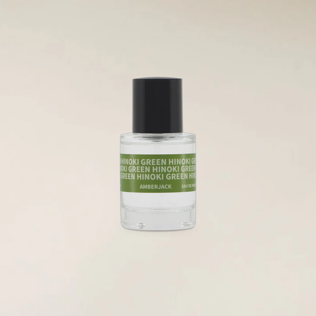 A small clear glass bottle of Amberjack fragrance with a black cap and a green label reading &