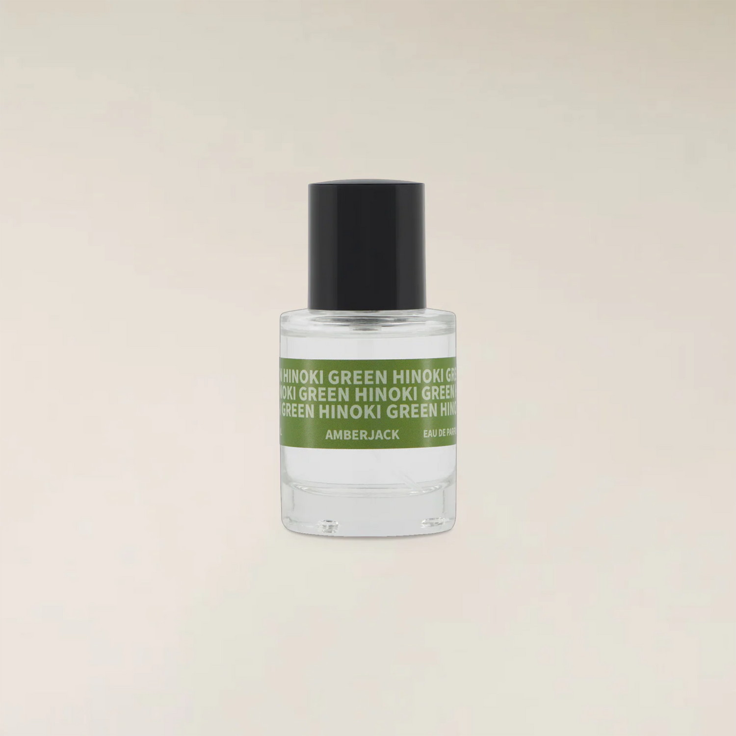 A small clear glass bottle of Amberjack fragrance with a black cap and a green label reading &