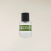 A small clear glass bottle of Amberjack fragrance with a black cap and a green label reading &