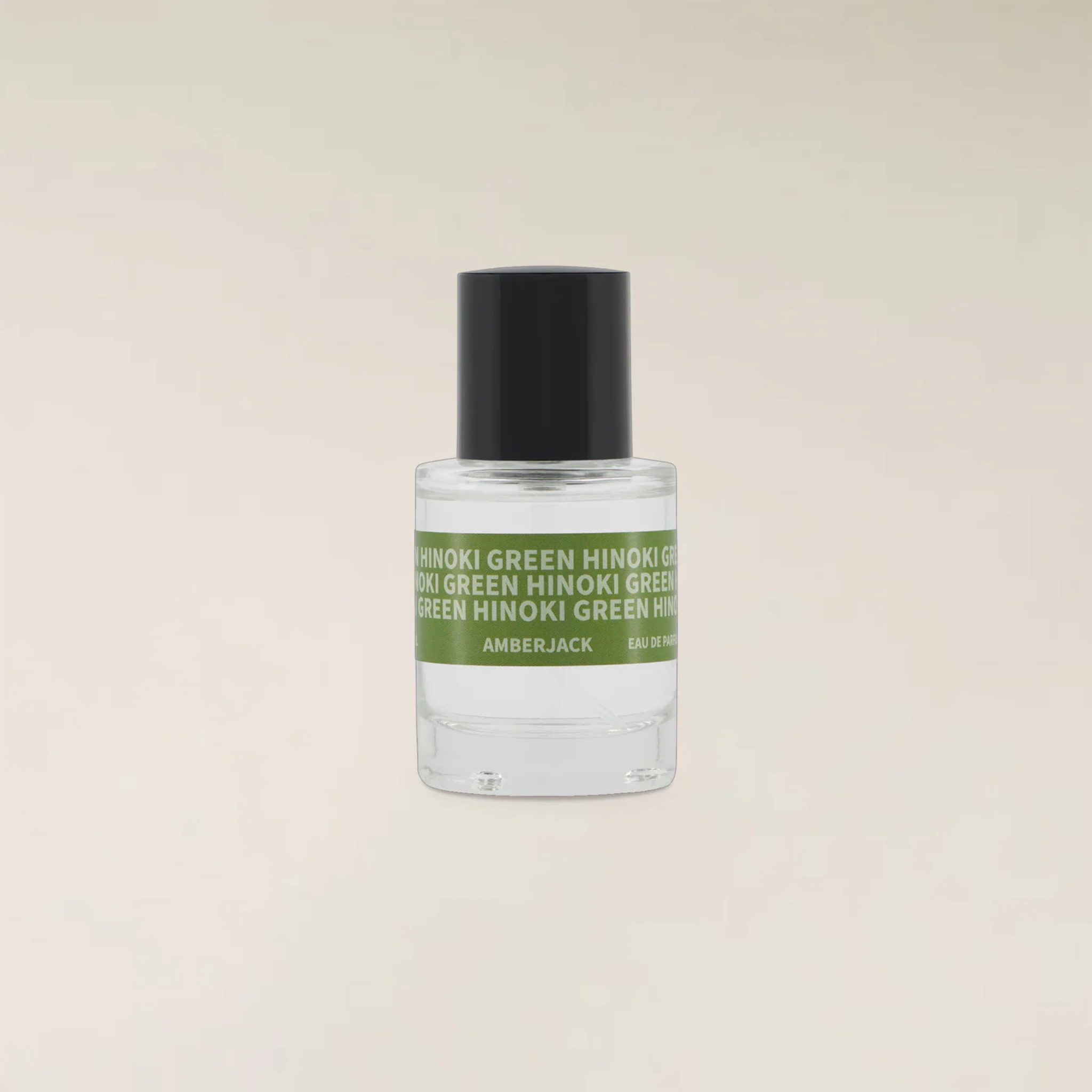 A small clear glass bottle of Amberjack fragrance with a black cap and a green label reading &