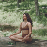Woman sitting on a log in a forest setting
