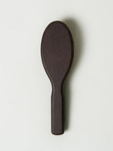 Dark wooden spoon on a light gray background
