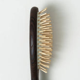 Wooden hairbrush with a dark handle on a light gray background