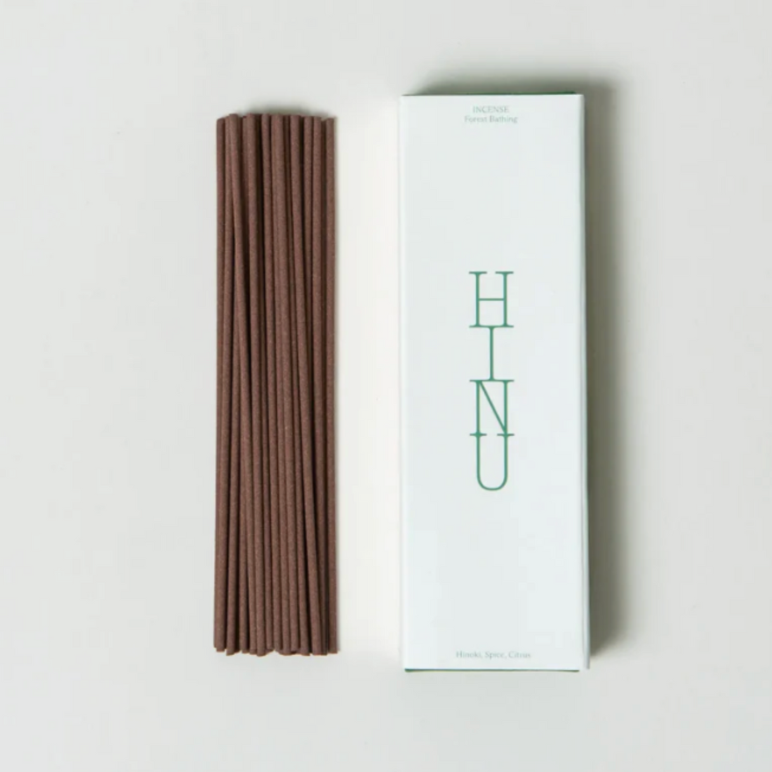 Brown incense sticks next to a white box with &