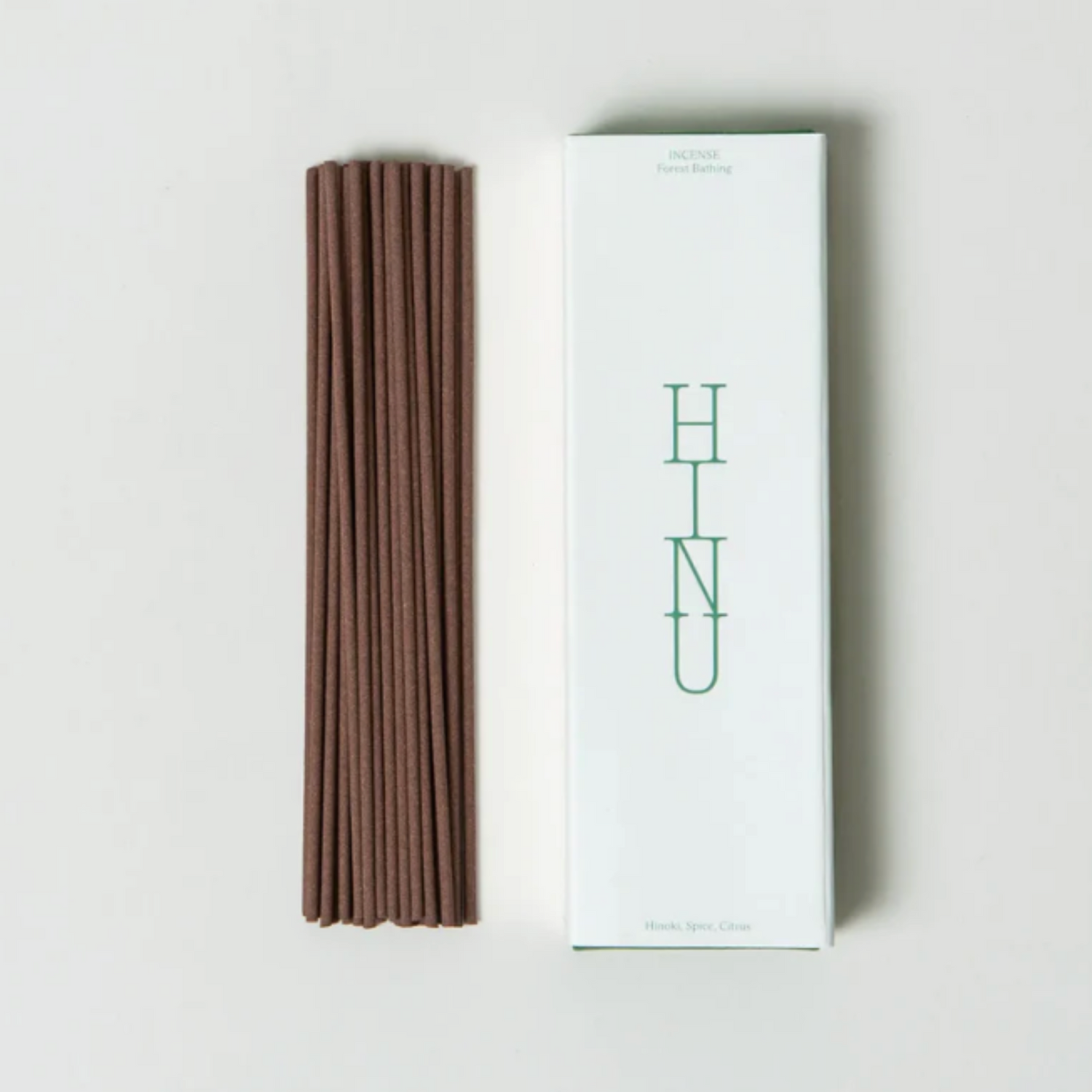 Brown incense sticks next to a white box with &