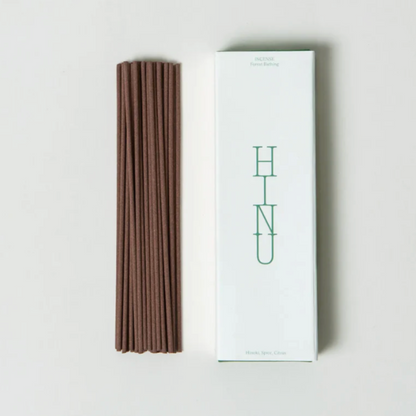 Brown incense sticks next to a white box with &