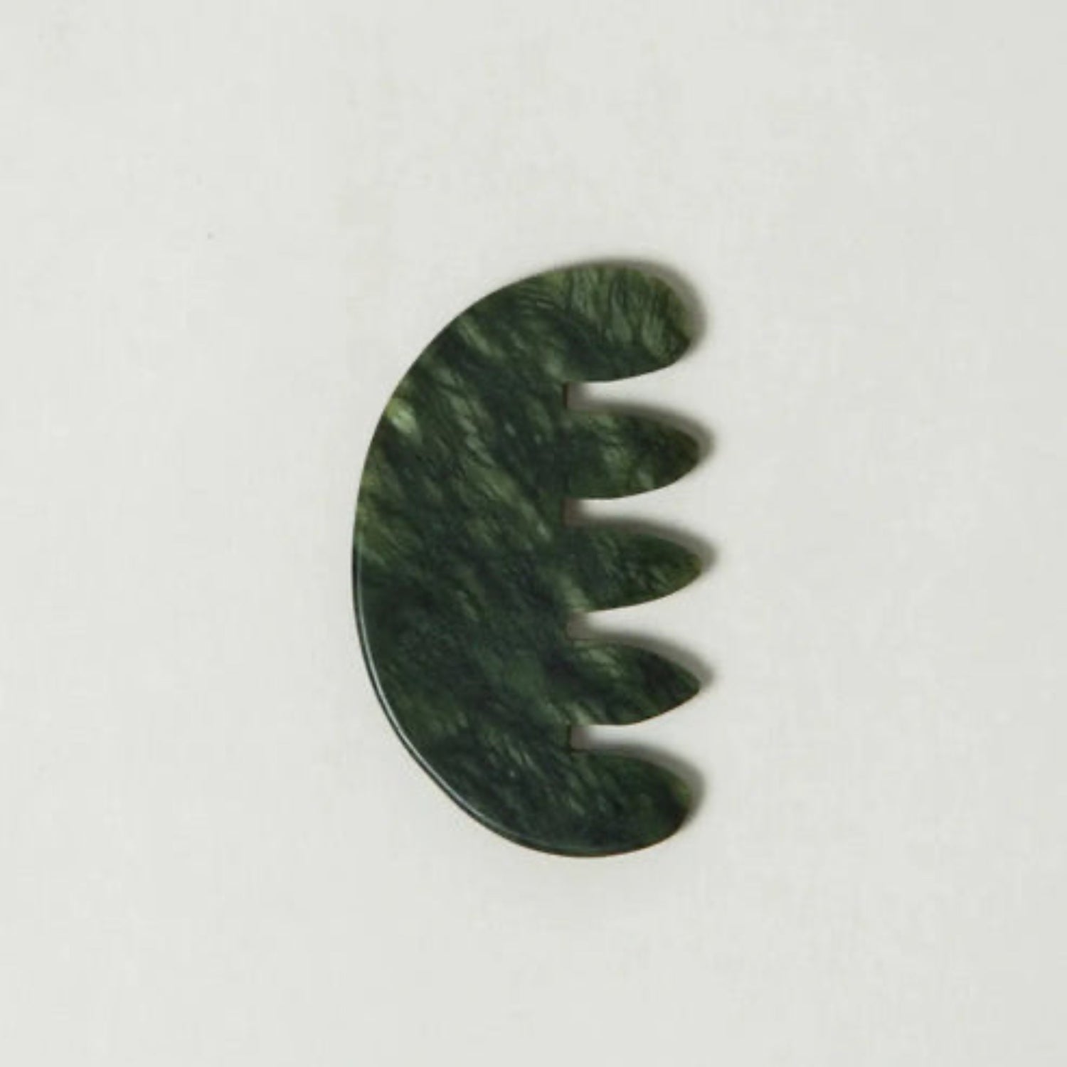 Green jade scalp stimulator on a white background