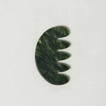 Green jade scalp stimulator on a white background