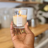 Hand holding a lit candle labeled &